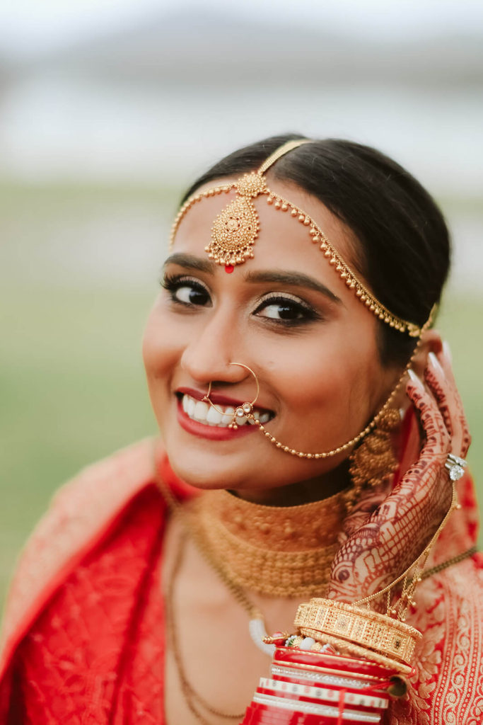 South Asian bride with traditional jewelry and henna. Photo by OkCrowe Photography.