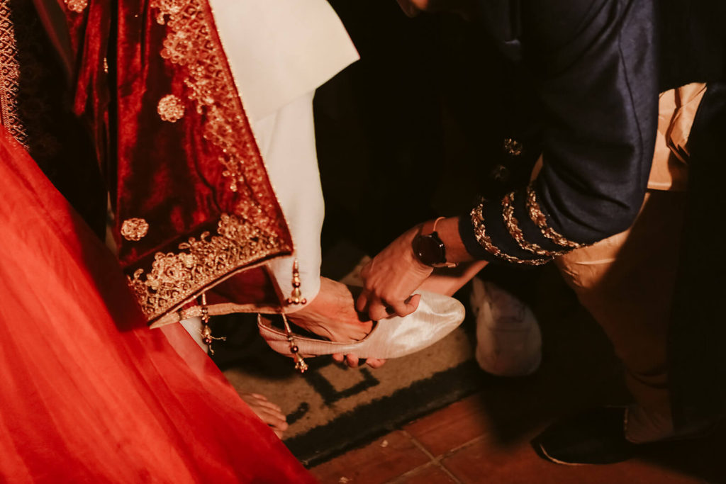 Wedding guest returning groom's wedding shoes to him. Photo by OkCrowe Photography.