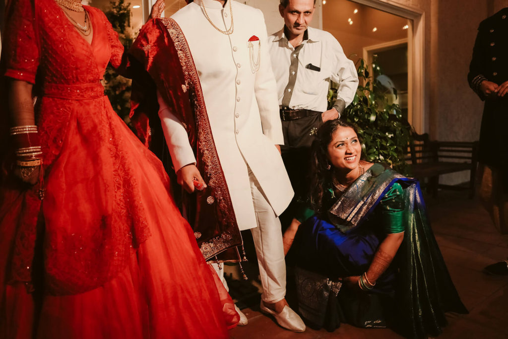 Indian bride and groom in traditional wedding garments with wedding guests. Photo by OkCrowe Photography.