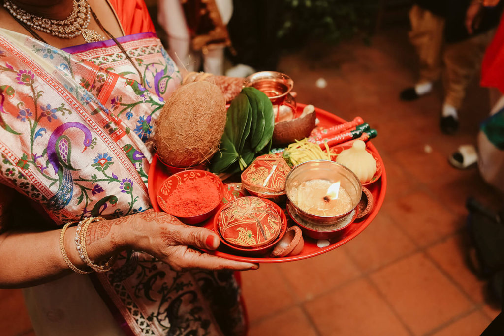 Platter with a candle, leaves, tilak, and perfumed water. Photo by OkCrowe Photography.