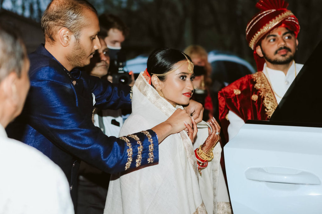 Father of the bride wrapping bride in a shawl as she leaves the wedding site with her groom. Photo by OkCrowe Photography.