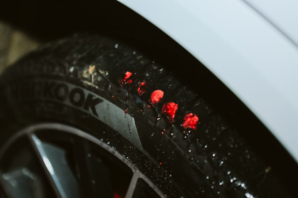 Tilak on the wheel of a car. Photo by OkCrowe Photography.