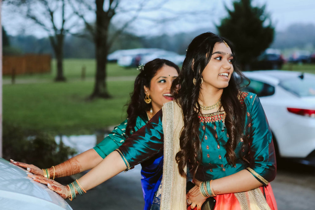 Indian wedding guests blessing the bride and groom's car before they leave the reception. Photo by OkCrowe Photography.