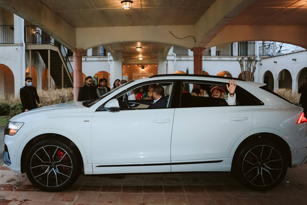 Groom waving from a white car as they leave Tennessee Riverplace. Photo by OkCrowe Photography.