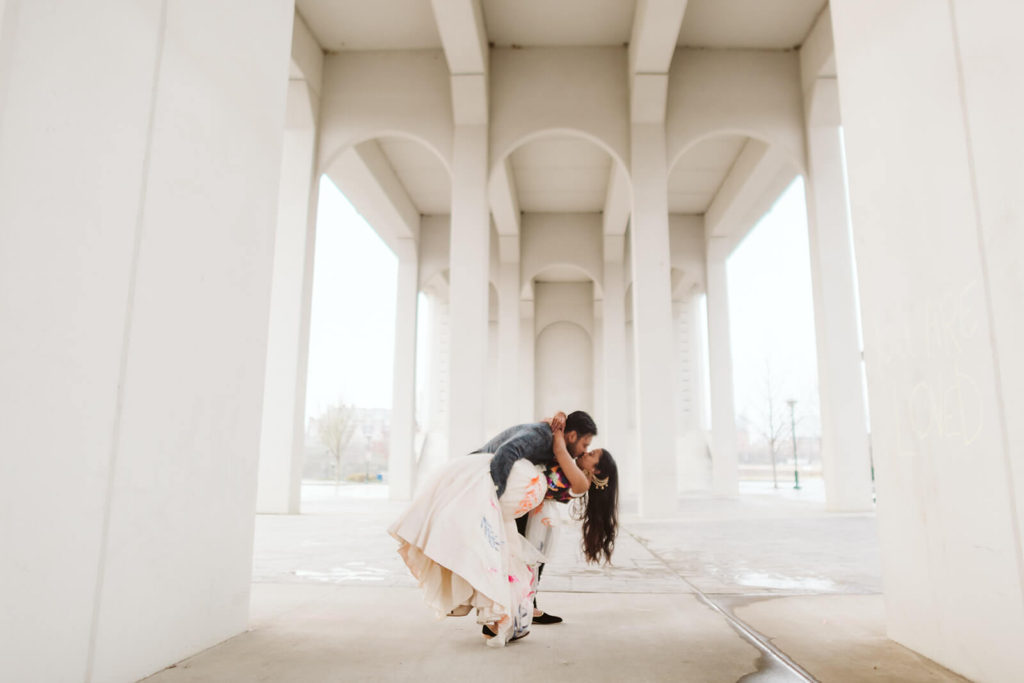 Groom dipping bride under bridge in downtown Chattanooga. Photo by OkCrowe Photography.