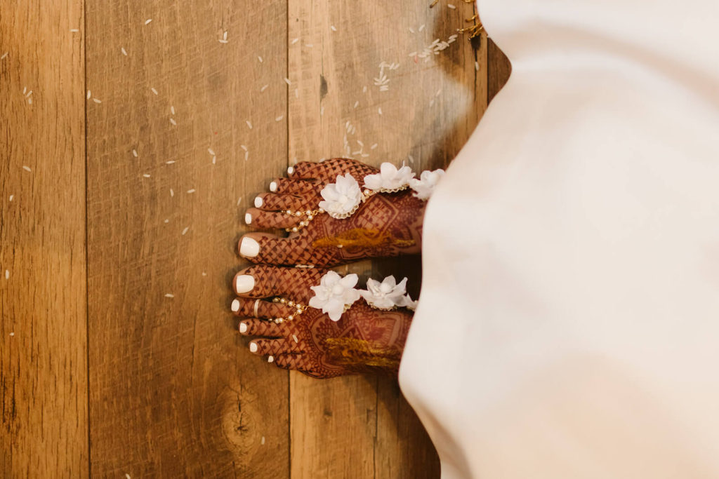 Bride's feet with henna designs and flowers. Photo by OkCrowe Photography.