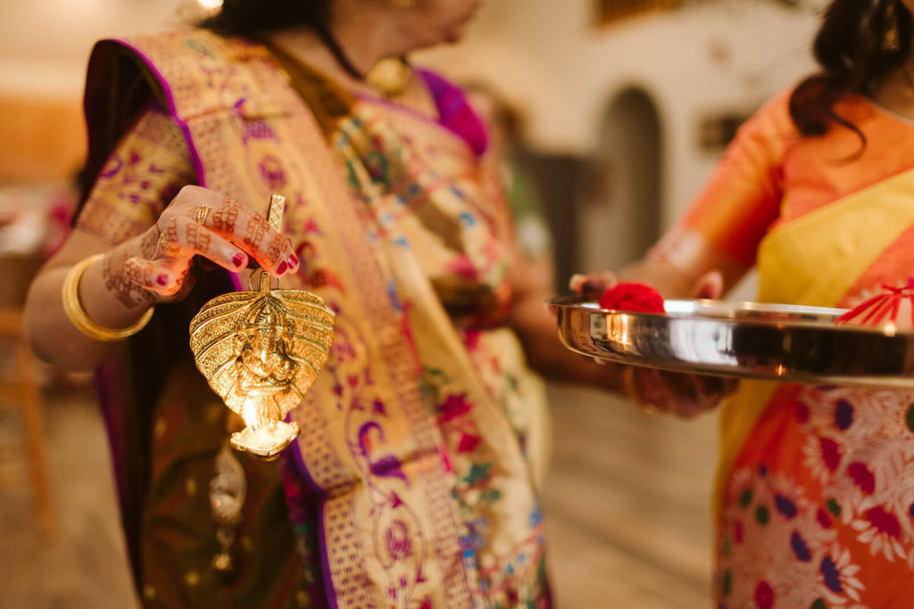 Family members wearing traditional South Asian garments preparing offering. Photo by OkCrowe Photography.