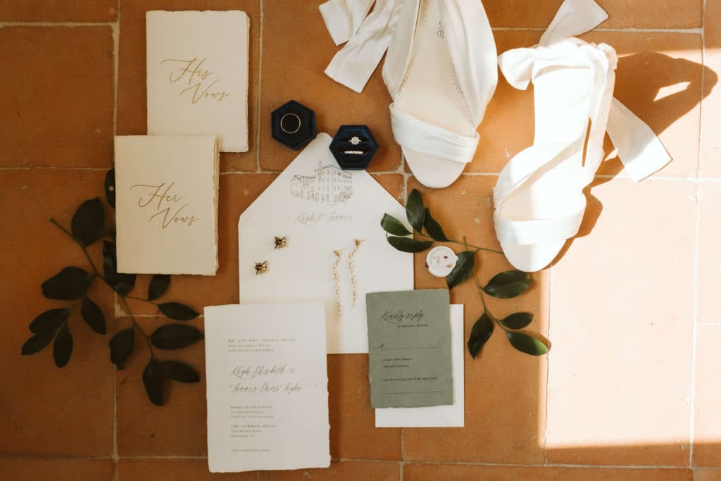 Flat lay of wedding invitations and bridal accessories. Photo by OkCrowe Photography.