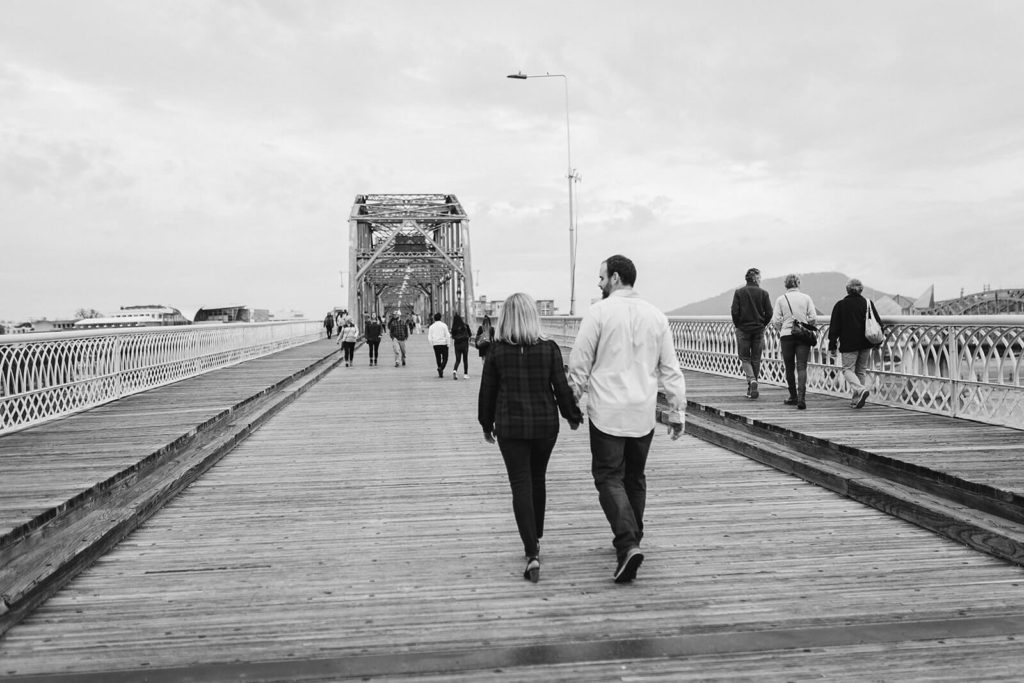 Engagement session on the Walnut St Bridge overlooking the river. Photo by OkCrowe Photography.