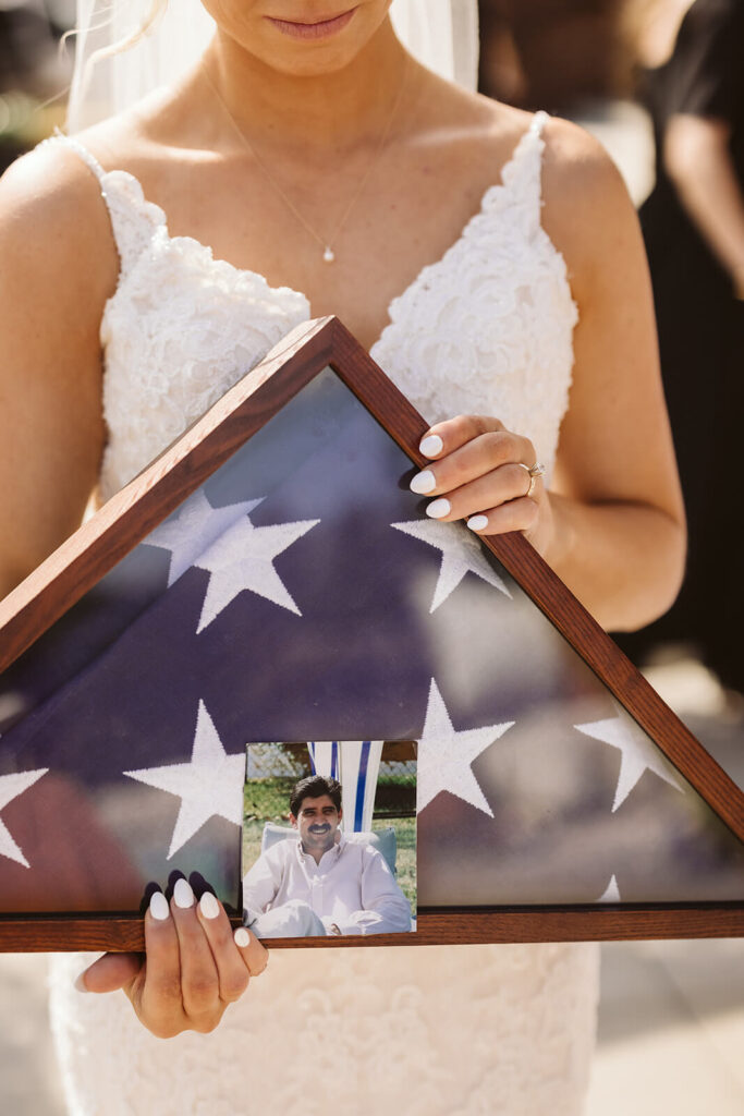 Bride carrying her veteran father's flag into the ceremony space. Photo by OkCrowe Photography.