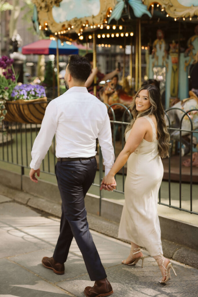 Spring engagement session by the carousel in Bryant Park, NYC. Photo by OkCrowe Photography.