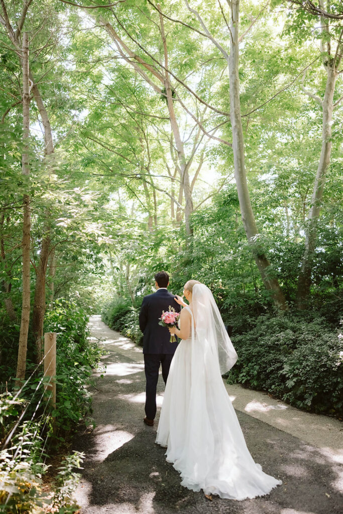 Bride and groom first look along a  forested path in Brooklyn Bridge Park. Photo by OkCrowe Photography. 