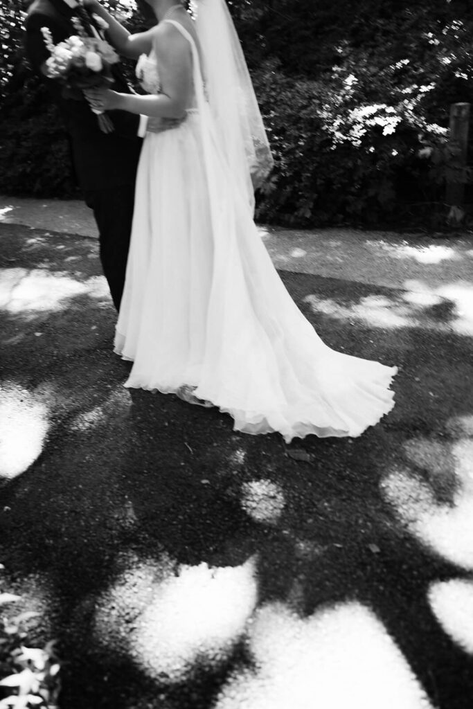 Bride and groom first look along a  forested path in Brooklyn Bridge Park. Photo by OkCrowe Photography. 