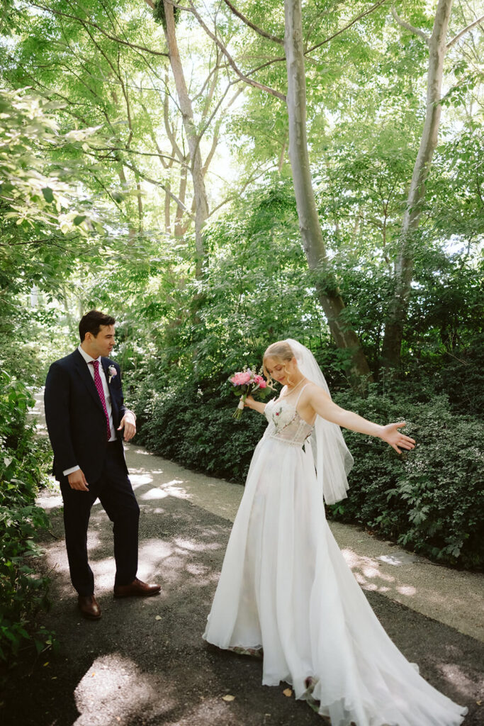 Bride and groom first look along a  forested path in Brooklyn Bridge Park. Photo by OkCrowe Photography. 