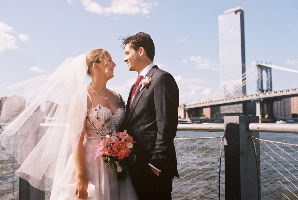 Bride and groom portraits along a  the waterfront in Brooklyn Bridge Park. Photo by OkCrowe Photography. 