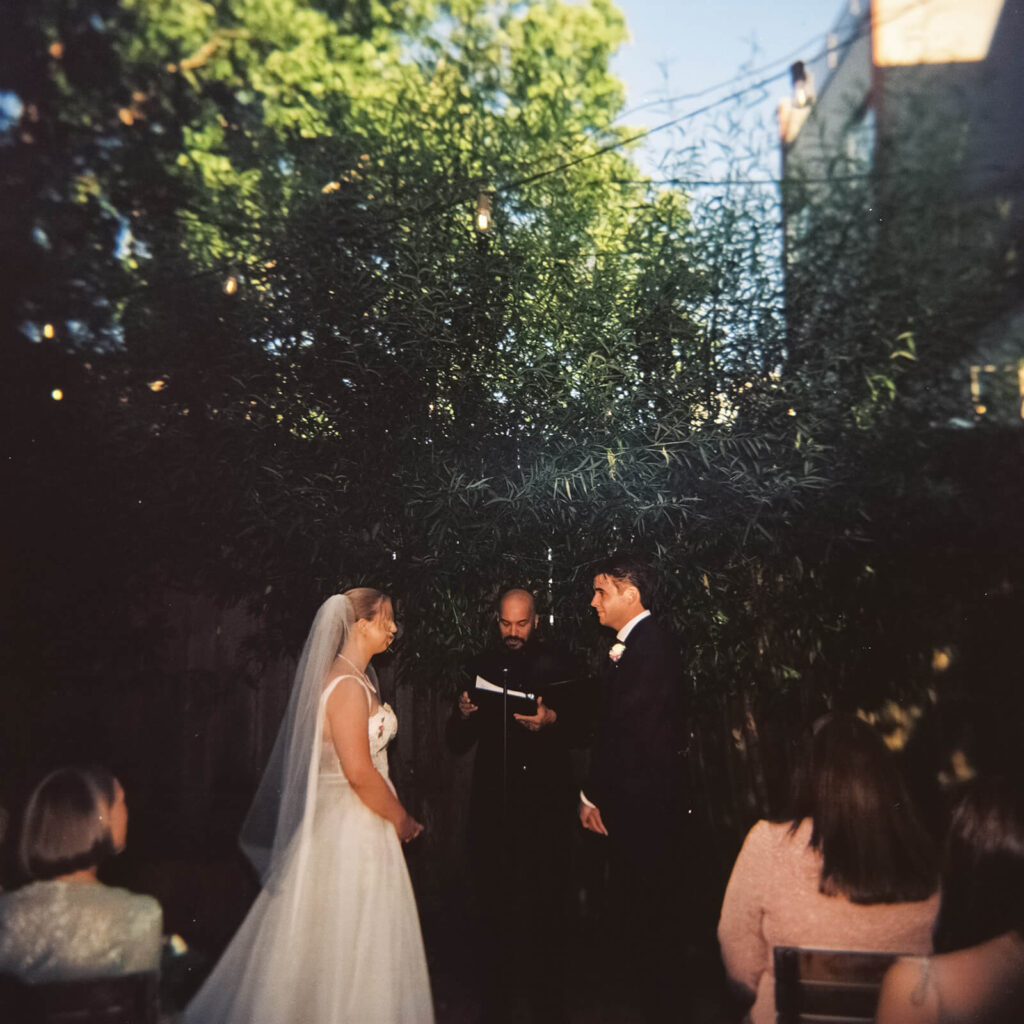 Backyard-style wedding ceremony in Frankies Spuntino's outdoor Garden space. Photo by OkCrowe Photography.