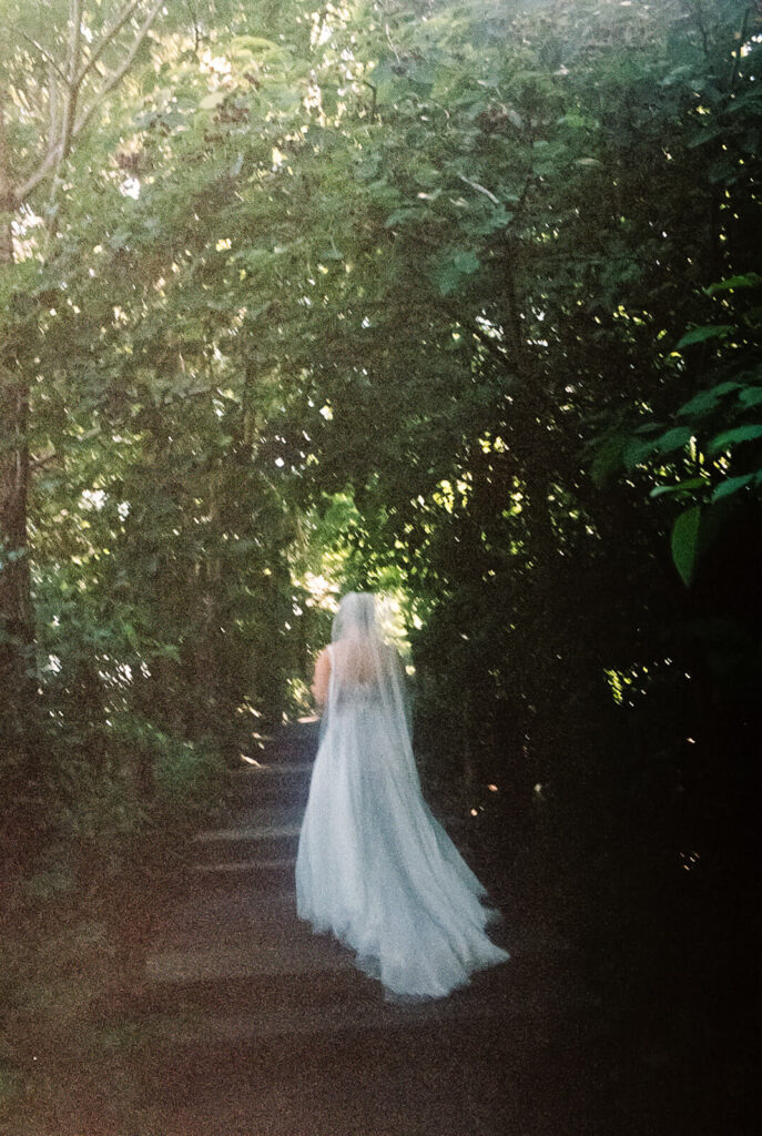 Bride and groom first look along a  forested path in Brooklyn Bridge Park. Photo by OkCrowe Photography. 