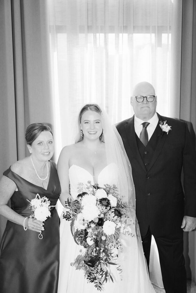 Portrait of a bride and her parents in an AirBnB for a wedding at the New York Botanical Gardens. Photo by OkCrowe Photography.
