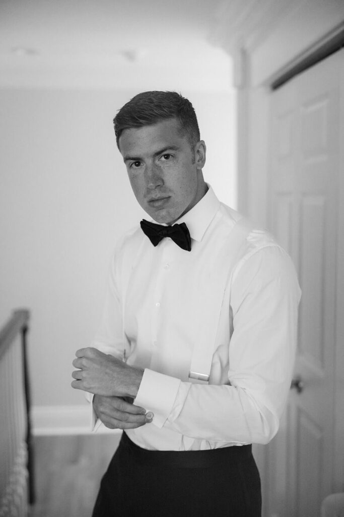 Groom getting ready in the bride's parents' home. Photo by OkCrowe Photography. 