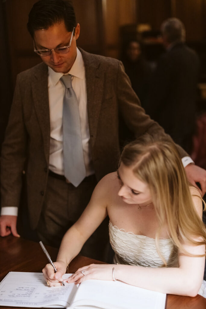 Bride and groom signing marriage license in the Princeton University Chapel. Photo by OkCrowe Photography.