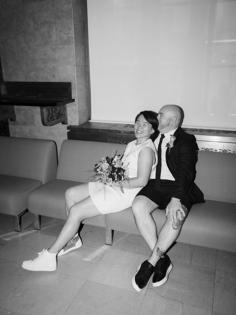 Bride and groom waiting for their ceremony to begin in the waiting room of the NYC Courthouse. Photo by OkCrowe Photography.