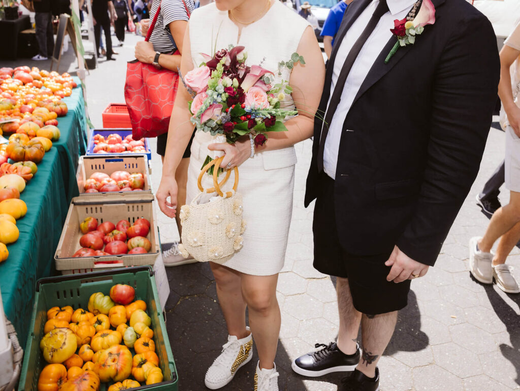 Newlyweds portraits at the Greenmarket in Union Square Park after their courthouse ceremony at the NYC Courthouse. Photo by OkCrowe Photography.