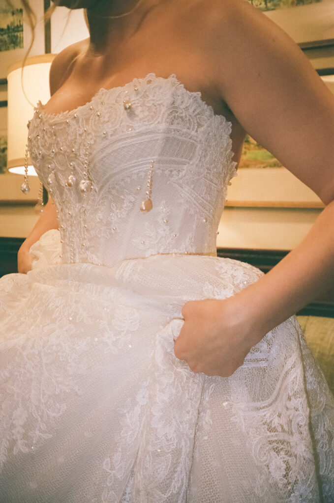 Bride wearing her wedding dress in the bridal suite at the Mansion at Oyster Bay. Photo by OkCrowe Photography.