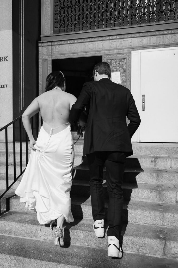 Bride and groom entering the NYC courthouse for their elopement. Photo by OkCrowe Photography.