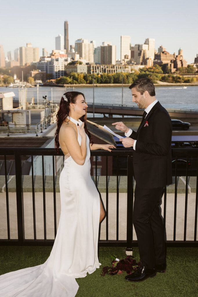 Newlyweds sharing private vows on the balcony of the 33 Seaport Hotel Brooklyn Bridge Grand Terrace Suite. Photo by OkCrowe Photography.