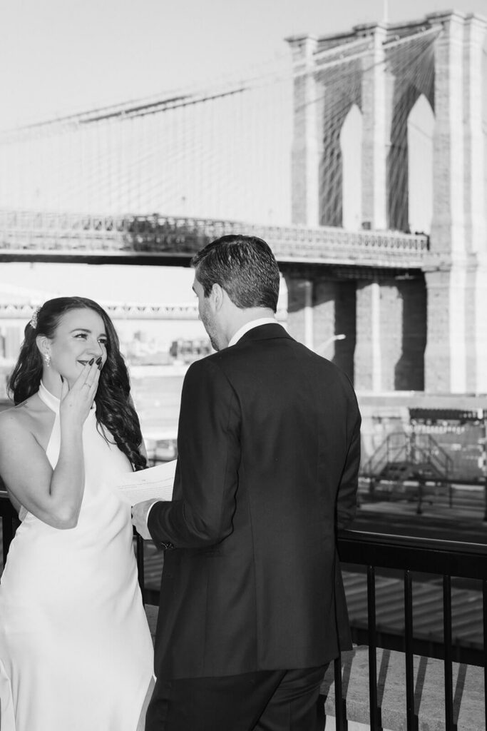 Newlyweds sharing private vows on the balcony of the 33 Seaport Hotel Brooklyn Bridge Grand Terrace Suite. Photo by OkCrowe Photography.