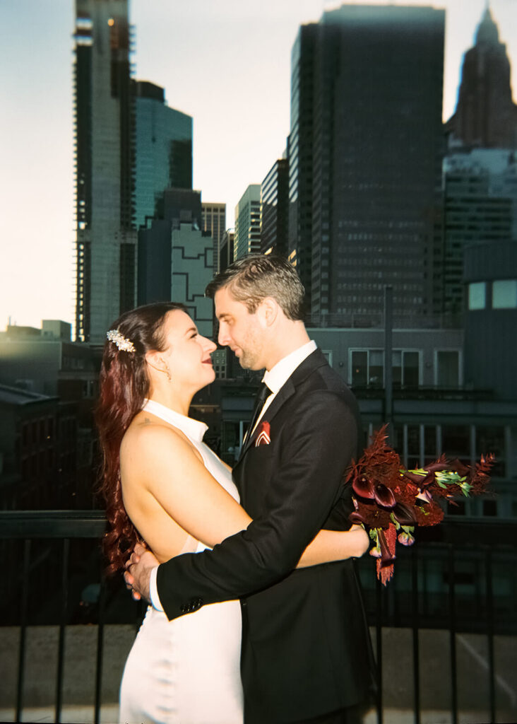 Newlywed photos on the balcony of the 33 Seaport Hotel Brooklyn Bridge Grand Terrace Suite. Photo by OkCrowe Photography.